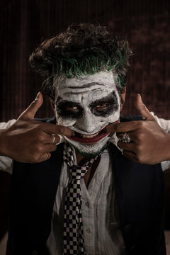 Portrait of an Indian man in Halloween costume showing scary facial expression in front of a casino poker table. Cosplay photography.