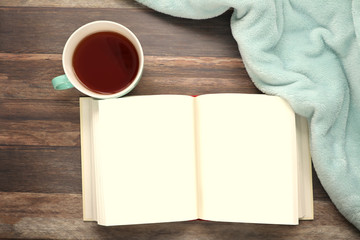 Obraz na płótnie Canvas Top view of an open blank book and a cup of tea on rustic wood surface 