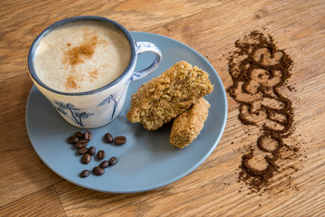 Cup of coffee with cinnamon and rusks.