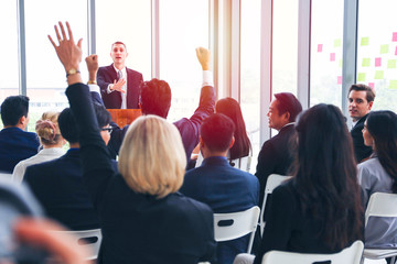 Fototapeta premium Group of business people or employees meeting or seminar in office hall, executive or professional smart speaker speaking on podium 