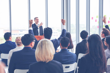 Group of business people or employees meeting or seminar in office hall, executive or professional smart speaker speaking on podium 