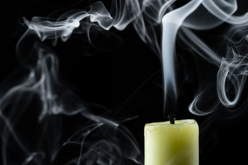 the smoke of an extinguished candle on a black background close up