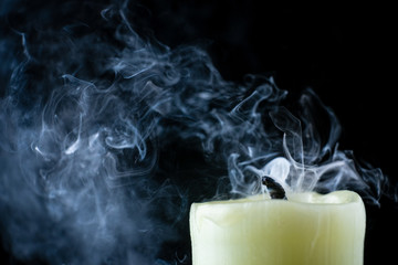 the smoke of an extinguished candle on a black background close up