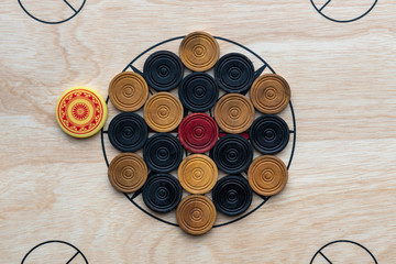 Carrom men and red arranged on the board around the center star. - obrazy, fototapety, plakaty