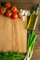 Wooden board with clear space. Around tomato and dill, olive oil, spice, peper, avocado, green...
