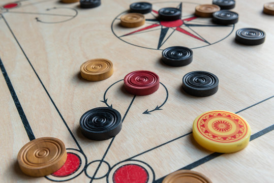 Carom board with striker and carom men. Selective focus.