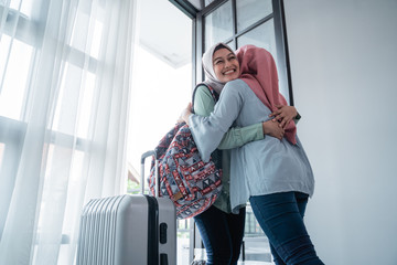 veiled woman hugs her sister when meeting at the door of the house after being away for a long time