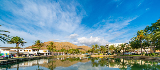 Fototapeta premium Lake in the park and palm trees around with mountains on the horizon