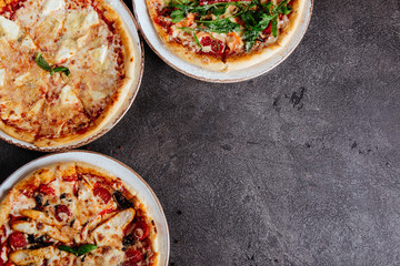 Traditional Italian pizza on a dark background top view copy space.