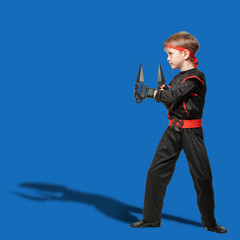 Naklejka premium Young male fighter training with kunai throwing knives