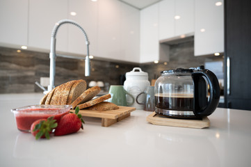 Breakfast table with bread coffee and strawberry jam