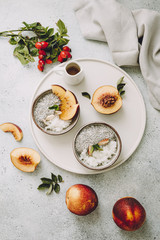 A healthy plant-based breakfast bowl with rice and chia seeds. Rice with Chia Pudding and Peaches on a grey background, selective focus. 