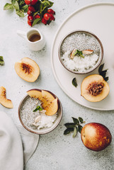 A healthy plant-based breakfast bowl with rice and chia seeds. Rice with Chia Pudding and Peaches on a grey background, selecctive focus