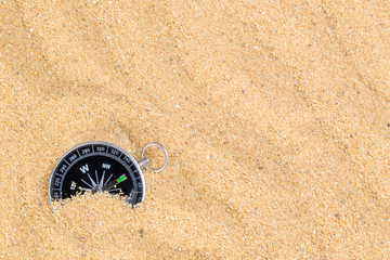 Fototapeta na wymiar Compass in the sea sand on beach background with copy space for add text message or use components for design. Summer Travel destination and Navigation Concept Backdrop.