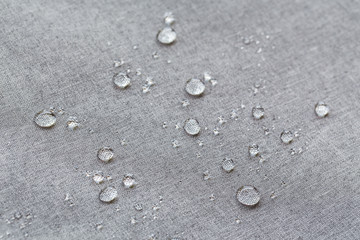 Fototapeta na wymiar Waterproof droplets on fabric. Grey Canvas Polyester texture synthetical for background. Black polyester textile backdrop for interior art design or add text message.