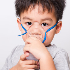 Closeup Asian face, Little children boy sick he using steam inhaler nebulizer mask inhalation...