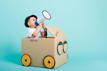 children boy smile in driving play car creative by a cardboard box imagination with megaphone