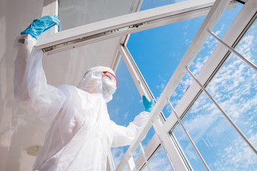 Tired doctor biohazard after hard shift in hospital, coronavirus looks at blue sky