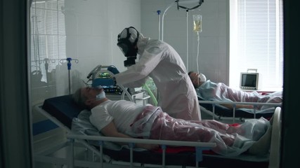 Hospital worker is putting an oxygen mask on a male patient - Powered by Adobe