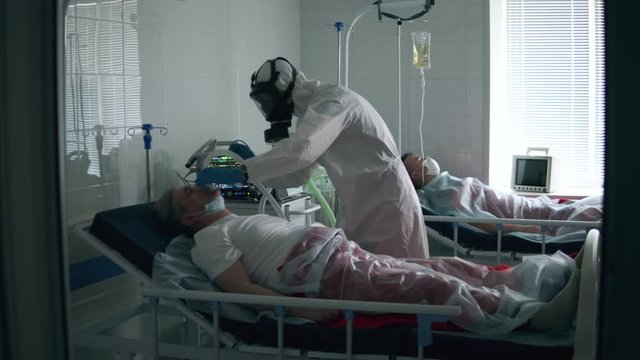 Hospital worker is putting an oxygen mask on a male patient