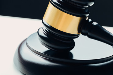 Judge's gavel with gold metal on a black table. Concept of law
