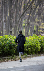 朝の公園でジョギングしている男性