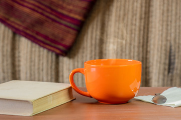 Cozy still life with an orange mug and a book