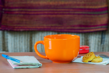 Cozy still life with an orange mug and a book