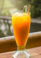 Healthy drink. Carrot-ginger-orange juice with a slice of lime in a glass