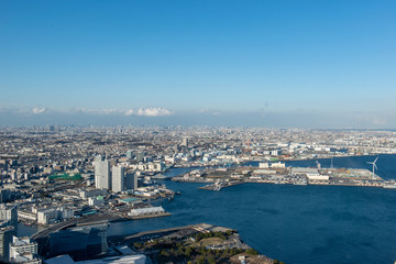 丹沢の山々を背景にした、横浜のオフィス街のビル群から川崎、東京方面の全景　空撮