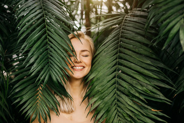 Woman in swimsuit on tropical plants background