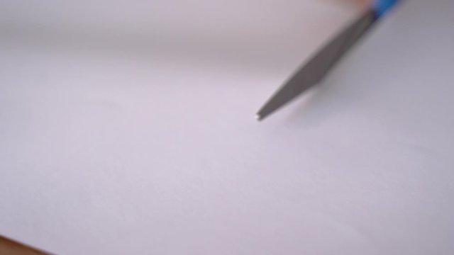 close up of hand cutting paper using scissor