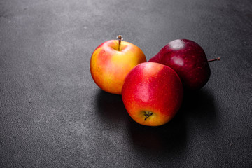 Fresh juicy red apple with droplets of water against dark background