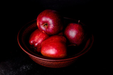 Fototapeta na wymiar Fresh juicy red apple with droplets of water against dark background