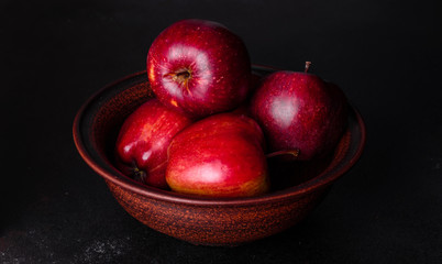Fototapeta na wymiar Fresh juicy red apple with droplets of water against dark background