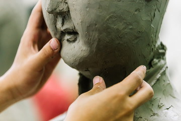 Head of sculpture and sculptor working with it