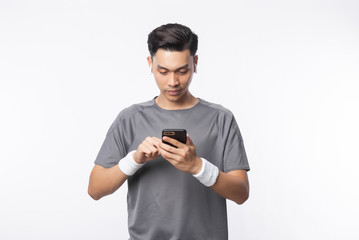 Young asian man in sport outfits playing smartphone and listening music with happy face isolated on white background.