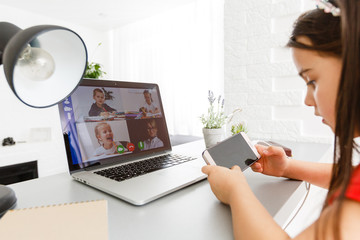 Pretty stylish schoolgirl studying homework math during her online lesson at home, social distance during quarantine, self-isolation, online education concept, home schooler