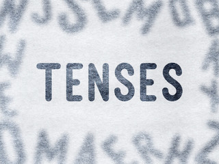 TENSES - Word on paper surrounded by blurry letters