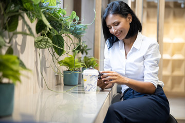 Fototapeta premium Young businesswoman using smartphone in coffee shop. Women relaxation coffee break, Lifestyle in city