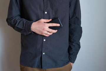 A man holding a smartphone in his hands. Businessman with a trendy portable gadget. Modern technology, wireless Internet. Mobile device for work and leisure. Freedom lifestyle, freelance work