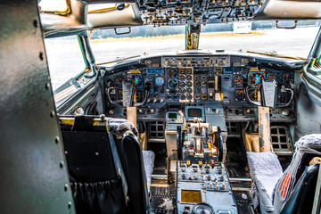 Detailed view of an old aircraft cockpit with two yokes and many gauges and switches
