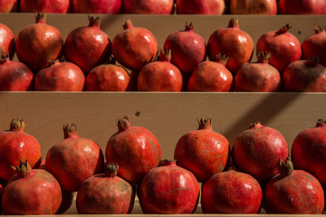 Pomegranates on wooden shelf at city market in Moscow