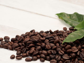 Roasted coffee beans with coffee leaves.