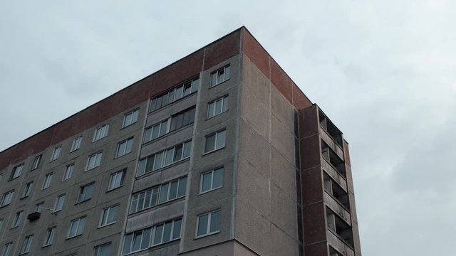 Architecture of authentic Soviet buildings, view of a gray residential building made of concrete, Soviet architecture of panel houses, close-up view of windows and balconies. 