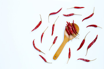 Dry red hot chili peppers on wooden spoon on white background.
