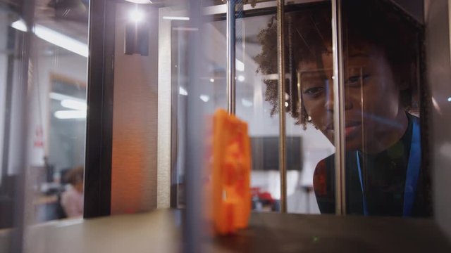 Female college student studying engineering using 3D printing machine - shot in slow motion