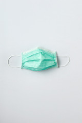 Still life of a green face mask on white background