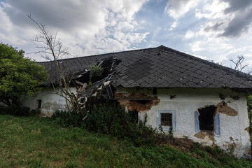Fototapeta na wymiar eingestuerztes dach von einem alten haus in den bergen
