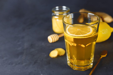 Antioxidant healthy green tea with lemon, ginger and honey on a dark background. Antiviral beverage.